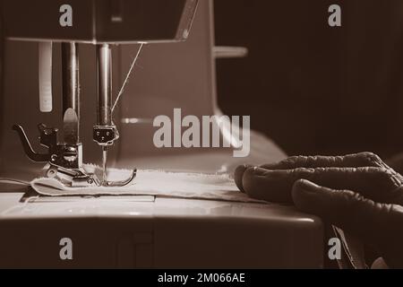 Nähmaschine und die Hand der alten Großmutter Stockfoto