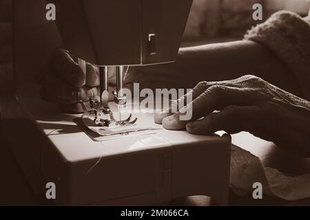 Nähmaschine und die Hand der alten Großmutter Stockfoto