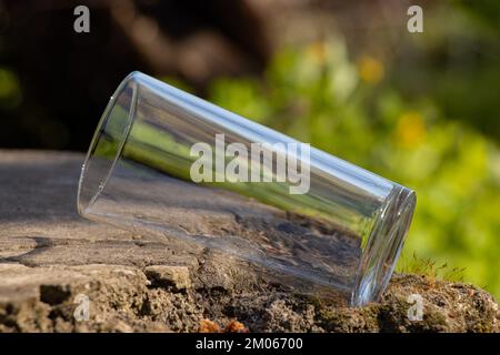 Ein leerer durchsichtiger Glasbecher steht auf dem Boden Stockfoto