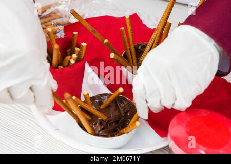 Schokolade, Keksstöcke in Gläsern auf dem Tisch. Stockfoto