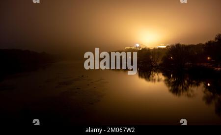 Leipzig, Deutschland. 04.. Dezember 2022. Der nächtliche Nebel strahlt das gelbe Licht aus dem Innern der Red Bull Arena in Leipzig aus. Die Woche endet mit kaltem und nassem Wetter. Kredit: Hendrik Schmidt/dpa/Alamy Live News Stockfoto