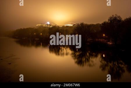 Leipzig, Deutschland. 04.. Dezember 2022. Der nächtliche Nebel strahlt das gelbe Licht aus dem Innern der Red Bull Arena in Leipzig aus. Die Woche endet mit kaltem und nassem Wetter. Kredit: Hendrik Schmidt/dpa/Alamy Live News Stockfoto