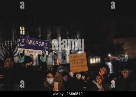 Seattle, Washington, USA. 28.. November 2022. Ein Protestteilnehmer, der das Straßenschild „Urumqi Middle Road“ hielt, das den Ursprung der Bewegung während der Demonstration symbolisiert. An der Universität von Washington versammelten sich mehr als zweihundert Menschen, um Solidarität mit dem "Weißbuch"-Protest in China zu zeigen. Die Demonstranten forderten die chinesische Regierung auf, alle Demonstranten freizulassen, China zu befreien, und forderten Präsident Xi auf, zurückzutreten. Die Demonstranten zündeten jedoch eine Kerze an, um eine Tragödie unter exzessiver Kontrolle zu symbolisieren, um ihre Unterstützung für die Tragödie des Urumqi-Feuers zu zeigen. Diese Tragödie hat es sich zum Ziel gesetzt Stockfoto