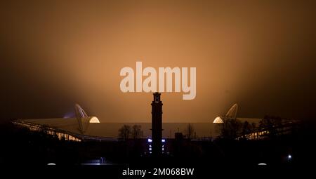 Leipzig, Deutschland. 04.. Dezember 2022. Der nächtliche Nebel strahlt das gelbe Licht aus dem Innern der Red Bull Arena in Leipzig aus. Die Woche endet mit kaltem und nassem Wetter. Kredit: Hendrik Schmidt/dpa/Alamy Live News Stockfoto