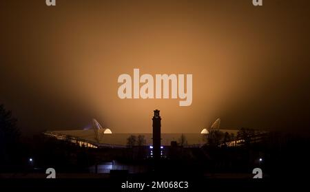 Leipzig, Deutschland. 04.. Dezember 2022. Der nächtliche Nebel strahlt das gelbe Licht aus dem Innern der Red Bull Arena in Leipzig aus. Die Woche endet mit kaltem und nassem Wetter. Kredit: Hendrik Schmidt/dpa/Alamy Live News Stockfoto