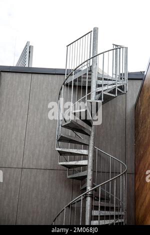 Metallspiraltreppe für Notausgang. Fassade des Gebäudes. Stockfoto