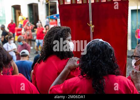 Salvador, Bahia, Brasilien - 04. Dezember 2022: Anhänger von Santa Barbara, die während der Messe im Largo do Pelourinho in der Stadt Salvador rot gekleidet waren. Stockfoto