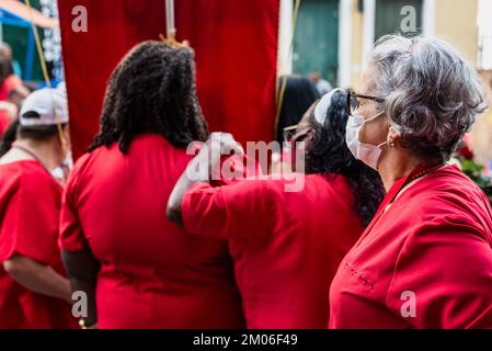 Salvador, Bahia, Brasilien - 04. Dezember 2022: Anhänger von Santa Barbara, die während der Messe im Largo do Pelourinho in der Stadt Salvador rot gekleidet waren. Stockfoto