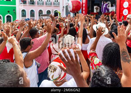 Salvador, Bahia, Brasilien - 04. Dezember 2022: Gläubige Katholiken von Santa Barbara erheben ihre Waffen zum Himmel zu Ehren des Weihnachtsmanns. Pelourinho, Salvador, Ba Stockfoto