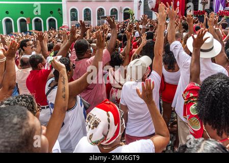 Salvador, Bahia, Brasilien - 04. Dezember 2022: Gläubige Katholiken von Santa Barbara erheben ihre Waffen zum Himmel zu Ehren des Weihnachtsmanns. Pelourinho, Salvador, Ba Stockfoto