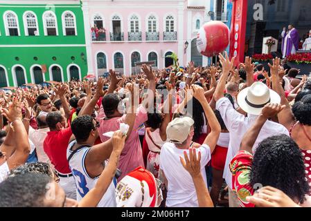 Salvador, Bahia, Brasilien - 04. Dezember 2022: Gläubige Katholiken von Santa Barbara erheben ihre Waffen zum Himmel zu Ehren des Weihnachtsmanns. Pelourinho, Salvador, Ba Stockfoto