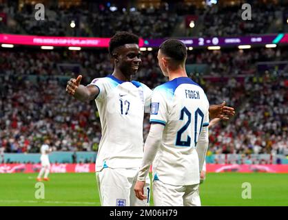 Der englische Bukayo Saka (links) feiert mit seinem Teamkollegen Phil Foden, nachdem er während des sechzehnten Spiels der FIFA-Weltmeisterschaft im Al-Bayt Stadium in Al Khor, Katar, das dritte Tor seiner Seite erzielt hat. Foto: Sonntag, 4. Dezember 2022. Stockfoto