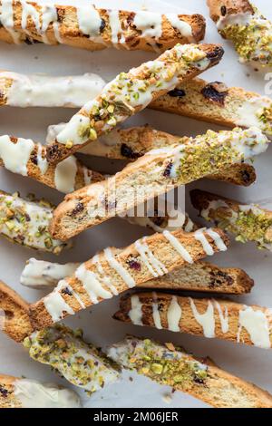 Blick von oben auf einen Haufen dekorierter Cranberry- und Pistazienbiscotti. Stockfoto