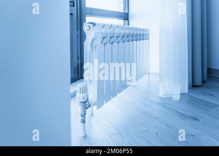 Weißer großer Heizkörper in der Nähe des Fensters in einem modernen Zimmer Stockfoto