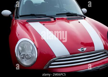 Rotes Auto mit weißen Streifen Mini Cooper auf der Straße abseits mit schwarzem Hintergrund geparkt. Vorderansicht des MINI Cooper-November 11,2022-Vancouv Stockfoto