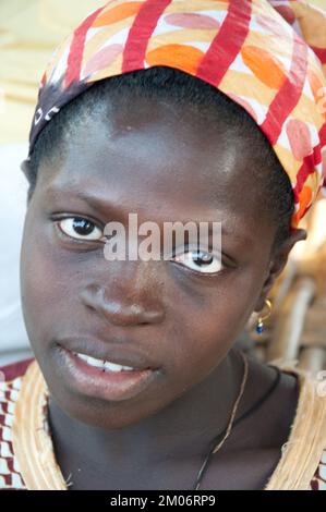 Gesichter Afrikas, Afrikanerin, Bafata, Guinea-Bissau; nachdenklicher Ausdruck; Schönes Kopfkleid Stockfoto