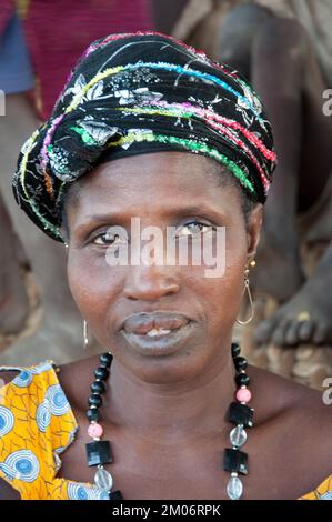 Gesichter Afrikas, Afrikanerin, Bafata, Guinea-Bissau - ängstliche Ausdrucksform; schönes Kopfkleid; Stockfoto