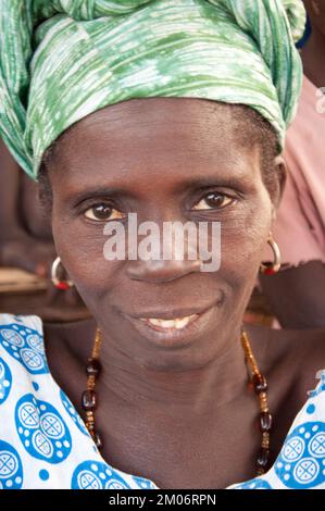 Gesichter Afrikas, Afrikanerin, Bafata, Guinea-Bissau - süßer Ausdruck; schönes Kopfkleid; Stockfoto