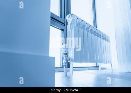 Weißer großer Heizkörper in der Nähe des Fensters in einem modernen Zimmer Stockfoto