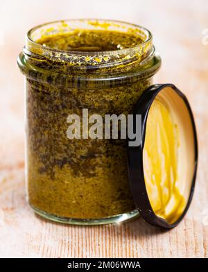 Bio-Pesto-Sauce im Glas auf Holzoberfläche Stockfoto