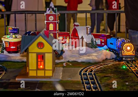 Ein Lionel-Zug umkreist ein Weihnachtsdorf, 18. November 2022, in Mobile, Alabama. Das Dorf war Teil einer Modelleisenbahn. Stockfoto