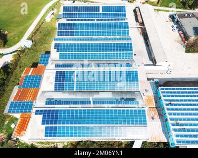 Dachdächer eines großen Industrielagers, das mit Solarpaneelen bedeckt ist Stockfoto