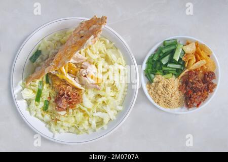 Soto Ayam (gelbe Hühnersuppe) mit Tempeh-Crackern ist ein beliebtes traditionelles Essen in Indonesien Stockfoto