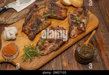 Frisch gekochtes Secreto iberico, iberisches Schwein, mit Chimichurri, Knoblauch, Zwiebeln, Salzschmuck, Rosmarin Stockfoto