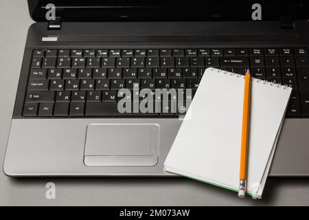 Blogger am Arbeitsplatz. Set zur Vorbereitung der öffentlichen Rede: Laptop, Notebook, Bleistift, Draufsicht. Stockfoto