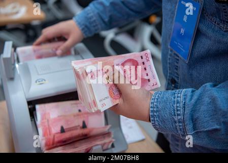 NANTONG, CHINA - 4. DEZEMBER 2022 - Bankmitarbeiter zählen Banknoten in Nantong, Ost-Chinas Provinz Jiangsu, 4. Dezember 2022. Stockfoto