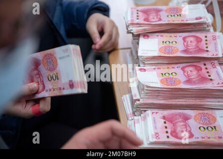 NANTONG, CHINA - 4. DEZEMBER 2022 - Bankmitarbeiter zählen Banknoten in Nantong, Ost-Chinas Provinz Jiangsu, 4. Dezember 2022. Stockfoto