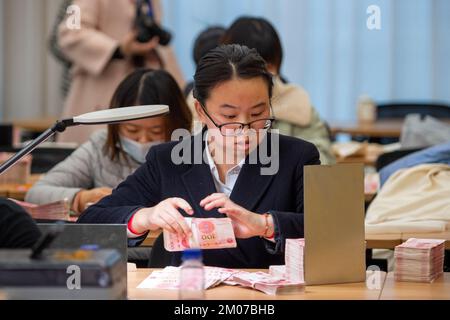 NANTONG, CHINA - 4. DEZEMBER 2022 - Bankmitarbeiter zählen Banknoten in Nantong, Ost-Chinas Provinz Jiangsu, 4. Dezember 2022. Stockfoto