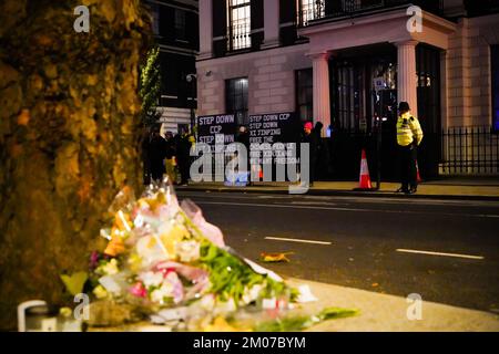 London, Großbritannien. 05.. Dezember 2022. Vor der chinesischen Botschaft werden Blumen gelegt, um den bei dem Brand in Urumqi verlorenen Menschenleben Tribut zu zollen. Dutzende Demonstranten versammeln sich vor der chinesischen Botschaft in London, Großbritannien, um größere politische Freiheiten in China zu fordern. Die Ausbrüche landesweiter chinesischer Proteste wurden durch einen tödlichen Brand in Urumqi am 24. November 2022 ausgelöst, bei dem 10 Menschen wegen strenger Covid-Lockdowns getötet wurden. Kredit: SOPA Images Limited/Alamy Live News Stockfoto