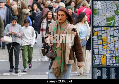 London, Großbritannien. 26.. November 2022. Eine Frau schaut auf ihr Handy, während sie auf der Oxford Street in London spaziert. (Foto: Dinendra Haria /SOPA Images/Sipa USA) Guthaben: SIPA USA/Alamy Live News Stockfoto