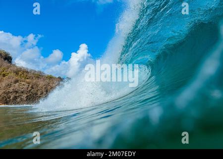 Die röhrenförmige Welle brach in das kristalline smaragdgrüne Meer ein und spritzte einen Schaum in Fernando de Noronha Stockfoto