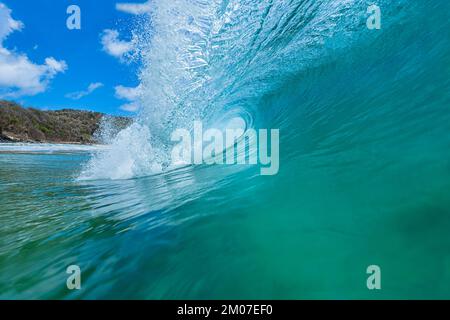 Die röhrenförmige Welle brach in das kristalline smaragdgrüne Meer ein und spritzte einen Schaum in Fernando de Noronha Stockfoto