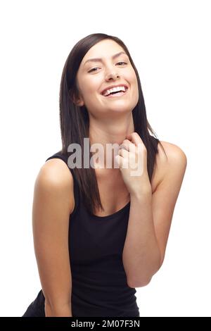 Hör auf, mich zum Lachen zu bringen. Eine süße junge Frau, die lacht, während sie auf weißem Hintergrund isoliert ist. Stockfoto