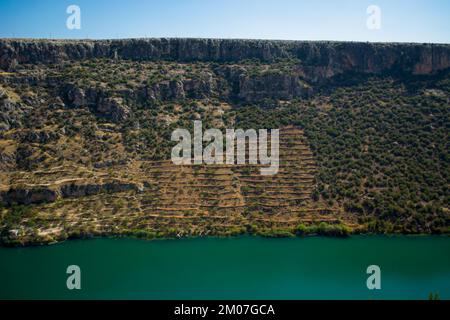 Landwirtschaftlich genutzte Flächen am Flussufer mit Terrassenverfahren auf Hochhangflächen Stockfoto