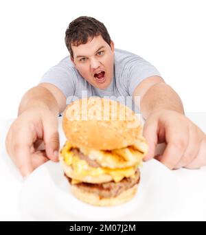 Er wird den Burger zerstören. Ein fettleibiger junger Mann, der sich einen riesigen Hamburger schnappte und aussah. Stockfoto