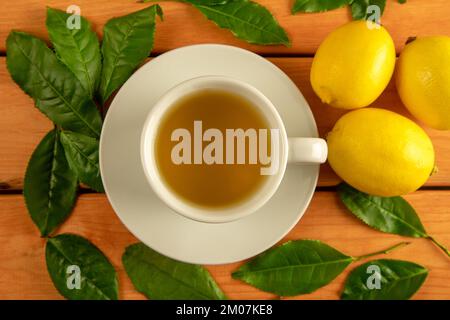 Eine Tasse grünen Tee, Teeblätter und Zitronen Stockfoto