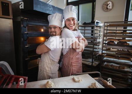 Porträt eines Mannes mit Down syndrom und seines Kollegen in der Bäckerei. Konzept der Integration von Menschen mit Behinderungen in die Gesellschaft. Stockfoto