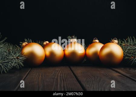 Farbige weihnachtsdekorationen auf schwarzem Holztisch. Weihnachtskugeln auf Holzhintergrund. Draufsicht, Kopierbereich. Neues Jahr Stockfoto