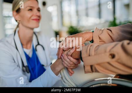 Nahaufnahme einer jungen Ärztin, die die Hand des Patienten hält und sie tröstet. Stockfoto