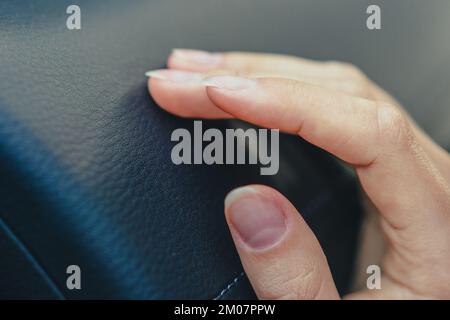 Nahaufnahme der Hand einer jungen Frau, die den Innenraum berührt. Stockfoto