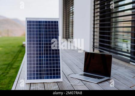 Nahaufnahme der Laptop-Ladetrocknung durch Solarmodul. Stockfoto