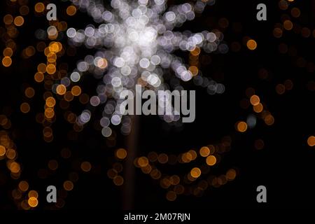 Goldene abstrakte gelbe, orangefarbene Bokeh-Lichter auf schwarzem Hintergrund mit Kopierbereich. Weihnachtskonzept, Grafikressourcen, gre Stockfoto