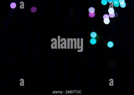 Goldene abstrakte gelbe, orangefarbene Bokeh-Lichter auf schwarzem Hintergrund mit Kopierbereich. Weihnachtskonzept, Grafikressourcen, gre Stockfoto