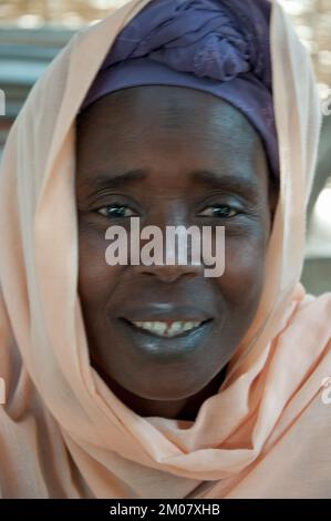 Gesichter Afrikas, Afrikanerin, Bafata, Guinea-Bissau - dezentes Lächeln; schönes Kopfkleid; Stockfoto