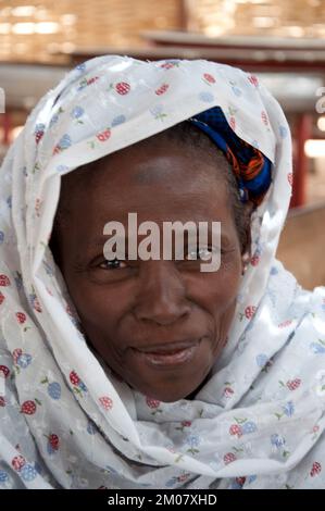 Gesichter Afrikas, Afrikanerin, Bafata, Guinea-Bissau - süßer Ausdruck; schönes Kopfkleid; schönes Lächeln Stockfoto