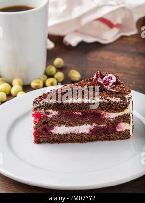 Kirschkuchen auf weißer Porzellanplatte auf Holztisch Stockfoto